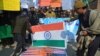 FILE - Supporters of Hafiz Saeed, head of the Pakistani religious charity Jamaat-ud-Dawa, burn representations of U.S. and Indian flags during a rally in Peshawar, Pakistan, Jan. 31, 2017. Saeed’s Jamaat-ud-Dawa is a front for Lashkar-e-Taiba. 