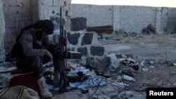 FILE - A Free Syrian Army fighter rests in an area south of Aleppo.
