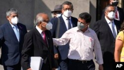 El presidente de Perú, Pedro Castillo, de camisa blanca, camina junto al primer ministro Aníbal Torres, segundo a la izquierda, y miembros de su gabinete afuera del palacio de gobierno en Lima, Perú, el 8 de marzo de 2022. 