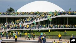 Protesters, supporters of Brazil's former President Jair Bolsonaro, storm the the National Congress building in Brasilia, Brazil, Sunday, Jan. 8, 2023. (AP Photo/Eraldo Peres)
