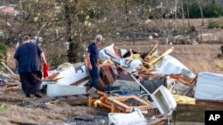 Scott Wayman, centro, examina su antigua casa de alquiler en 1349 County Road 43 después del mal tiempo, el 12 de enero de 2023, en Prattville, Alabama, EEUU.