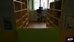 A man works with his laptop in a public library in Irpin, northwest of Kyiv, on Dec. 23, 2022, amid the Russian invasion of Ukraine.