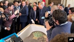 Egyptian Foreign Minister Sameh Shoukry, center right, and Mostafa Waziri, top official at the Supreme Council of Antiquities, talk in front of an ancient wooden sarcophagus during a handover ceremony at the Foreign Ministry in Cairo, Egypt, Jan. 2, 2023.
