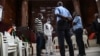 Sidi Mohamed Kounta et Hantao Ag Mohamed Cisse, deux des quatre accusés de l'attaque de Grand Bassam, se tiennent debout après avoir été condamnés à la prison à vie, le 28 décembre 2022. AFP / Sia Kambou
