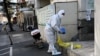 A worker wearing personal protective equipment (PPE) during the Covid-19 pandemic is seen along a street in Beijing, China, Dec. 11, 2022. 