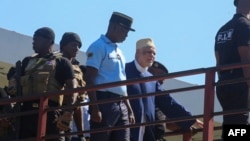 Ahmed Abdallah Sambi escorté par les gendarmes au début de son procès.