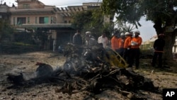 Investigators examine the wreckage of a car at the site of bomb explosion, in Islamabad, Pakistan, Dec. 23, 2022. 