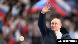 El presidente ruso, Vladimir Putin, saluda a la audiencia durante un mitin con motivo del 8º aniversario de la anexión de Crimea, en el estadio Luzhniki de Moscú, el 18 de marzo de 2022.