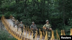 Pasukan Keamanan Perbatasan India (BSF) berpatroli di atas jembatan yang dibangun dekat garis kontrol (LoC), di wilayah Sabjiyan, distrik Poonch, 8 Agustus 2013. Garis LoC merupakan sebuah garis gencatan senjata yang memisahkan wilayah Kashmir yang disengketakan India dan Pakistan (Foto: dok). 