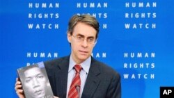Human Rights Watch executive director Kenneth Roth shows the group's annual review during a media conference at the Residence Palace in Brussels, 24 Jan 2011.