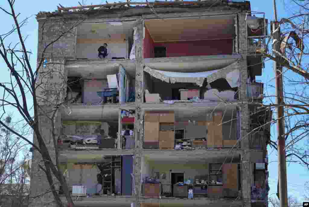 Un hombre entra en su apartamento en ruinas después de un bombardeo ruso en Kiev, Ucrania, el lunes 21 de marzo de 2022. Al menos ocho personas murieron en el ataque. (Foto AP/Efrem Lukatsky)