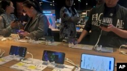 People try out Huawei smartphone models on display at an electronic store in Beijing, China, May 20, 2019. 