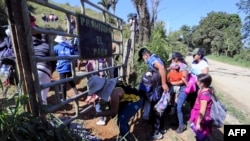 Migrantes que quieren llegar a EEUU, en su mayoría hondureños y nicaragüenses, cruzan de Honduras a Guatemala a través de un sendero ilegal, en Corinto, Honduras, el 15 de enero de 2022. 