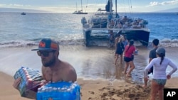 Un grupo de voluntarios lleva agua y otros suministros a la isla de Maui el 12 de agosto de 2023.