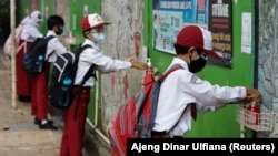 Siswa SD yang memakai masker sedang mencuci tangan usai sekolah, di Jakarta, 30 Agustus 2021. (Foto: REUTERS/Ajeng Dinar Ulfiana)