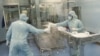Des employés de la grande société pharmaceutique sud-africaine Aspen Pharmacare travaillent dans l'usine de vaccins Johnson & Johnson à Gqeberha, Afrique du Sud, le 25 octobre 2021.