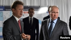 FILE - Russian President Vladimir Putin listens to Gazprom Chief Executive Alexei Miller during a visit to a construction site of the Gazprom's Amur gas processing plant near the far eastern town of Svobodny, in Amur region, Russia, Aug. 3, 2017.
