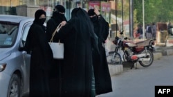 Sejumlah perempuan yang mengenakan hijab berkumpul di salah satu area di jalanan Kota Kabul, pada 7 Mei 2022.(Foto: AFP/Ahmad Sahel Arman)