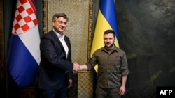 This handout picture taken and released by the Ukrainian president press service on May 8, 2022 shows President Volodymyr Zelensky (R) shaking hands with Croatia's Prime minister Andrej Plenkovic. (Photo by handout /Ukrainian Presidential Press Service/AFP)