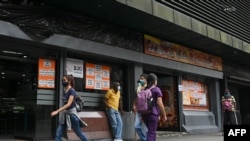 Con una economia nacional en crisis, muchos mecanismos ilícitos se mueven tras bastidores en Venezuela, de acuerdo a un informe de Transparencia Venezuela. Restaurante muestra carteles con precios de productos en dólares estadounidenses, en Caracas, el 22 de abril de 2022.