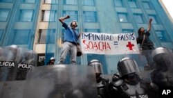 Estudiantes sostienen un cartel durante una protesta contra oficiales que eliminaron a civiles en el caso conocido por "falsos positivos", en Bogotá, Colombia, el 7 de abril de 2011. 