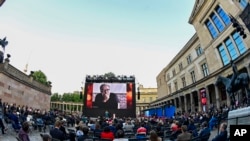Para penonton menghadiri Berlinale Summer Festival ke-71 di Berlin, Jerman, pada 13 Juni 2021. Foto dari Mohammad Rasoulof, yang menjadi anggota juri internasional pada festival tahun 2021, terpasang di layar di tengah-tengah penonton. (Foto: AFP via AP/Tobias Schwarz) 