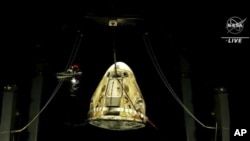 En esta imagen hecha a partir de un video proporcionado por la NASA, la cápsula espacial SpaceX Dragon sale del agua después de caer en el Golfo de México la madrugada del viernes 6 de mayo de 2022. (NASA vía AP)