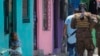 Una anciana observa a soldados que patrullan las calles del barrio San José del Pino en Santa Tecla (El Salvador) el 6 de abril del 2022. Foto AP.