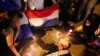 Manifestantes simulan un funeral con un muñeco mientras participan en una protesta contra las políticas de salud del presidente de Paraguay, Mario Abdo Benítez, en Asunción, el 10 de marzo de 2021. de 2021.