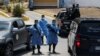 Miembros de la policía militar, con equipo de protección, bloquean la entrada de un cementerio antes del entierro de una víctima del coronavirus (COVID-19), en Tegucigalpa, Honduras.