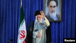 មេដឹកនាំកំពូលអ៊ីរ៉ង់លោក Ayatollah Ali Khamenei លើកដៃ មុនពេលធ្វើសុន្ទរកថាអំឡុងពេលពិធីគម្រប់​ខួប​ទី៣០ នៃ​ការ​ស្លាប់​របស់​ស្ថាបនិក​សាធារណរដ្ឋ​ឥស្លាម​នៅក្រុងតេរ៉ង់។ 