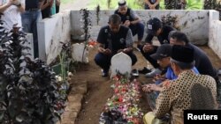 Los jugadores y funcionarios del Arema FC rezan ante las tumbas de las víctimas que murieron durante un motín y una estampida después de un partido de fútbol entre Arema y Persebaya en el estadio Kanjuruhan en Malang, provincia de Java Oriental, Indonesia, el 3 de octubre de 2022, en esta foto tomada por Antara Foto. Antara Foto/H Prabowo/vía REUTERS