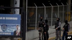 ARCHIVO - Un grupo de agentes de la policía política venezolana, SEBIN, con el rostro cubierto, hacen guardia en la puerta principal de la sede del SEBIN en Caracas, Venezuela, el miércoles 16 de mayo de 2018.