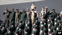 En esta imagen proporcionada por el sitio web oficial de la oficina del líder supremo de Irán, el ayatolá Ali Jamenei, se ve a Jamenei, en el centro, pasando revista a cadetes de las fuerzas armadas durante su ceremonia de graduación, en Teherán, el lunes 3 de octubre de 2022. 