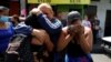 Mujeres reaccionan al reconocer a sus familiares detenidos que están siendo trasladados a una prisión después de que el Congreso de El Salvador aprobara reformas penales tras 89 asesinatos denunciados, durante el fin de semana en San Salvador, El Salvador, el 1 de abril de 2022