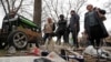 Warga lokal tampak menunggu barang-barang elektronik milik mereka yang tengah dicas dengan generator di sebuah pasar di Mariupol, Ukraina, pada 19 April 2022. (Foto: Reuters/Alexander Ermochenko)