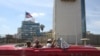 FILE - Tourists ride in a vintage car in front of the U.S. Embassy in Havana, Cuba, March 17, 2016.