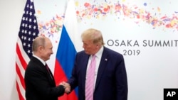 FILE - President Donald Trump and Russian President Vladimir Putin greet each other on the sidelines of the G-20 summit in Osaka, Japan, June 28, 2019.