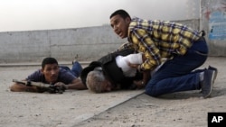 Egyptian security forces help the lifeless body of Giza Police Chief Gen. Nabil Farag, center, who was killed after unidentified militants opened fire on security forces in Kerdasah, Sept. 19, 2013.