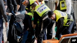 이스라엘 구호요원들이 23일 예루살렘에서 사망한 팔레스타인 공격범의 시신을 회수하고 있다.