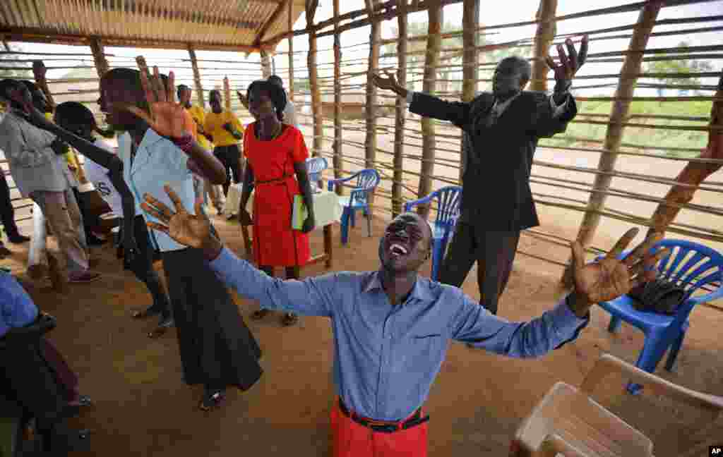 Wani mai wa'azi ya durkusa yana addu'a tare da yin kuka a mujami'ar Pentecostal dake sansanin 'yan gudun Bidi Bidi na arewacin Uganda 
