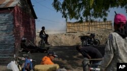Haitianos que ganan dinero como conductores de mototaxis y personal de mantenimiento, esperan a los clientes en el batey Ocho en la provincia de Bahoruco, República Dominicana, el miércoles 15 de mayo de 2024.