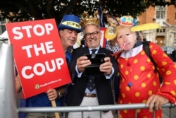 FILE - Dr. David Nicholl, center, demonstates with activists near the Houses of Parliament in London, Sept. 3, 2019.