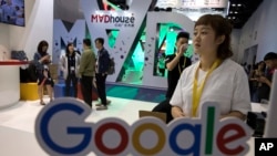 Visitors talk to staff members at a Google stand during the Global Mobile Internet Conference (GMIC) in Beijing, China, April 28, 2017. Google's search engine and email service remains blocked in mainland China but Chinese companies make use of its ad se