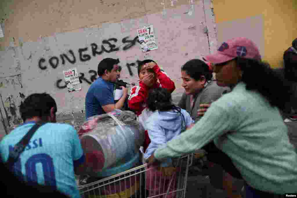 Personas afectadas por los gases lacrimógenos intentan recuperarse mientras los manifestantes participan en una protesta exigiendo elecciones presidenciales y el cierre del Congreso luego de que Pedro Castillo fuera detenido en una prisión policial luego de su destitución, en Lima, Perú, el 8 de diciembre de 2022. REUTERS/Sebastián Castañeda 