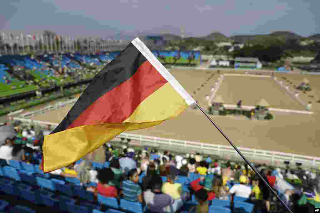 A German fan waves a flag during the equestrian eventing dressage competition at the 2016 Summer Olympics in Rio de Janeiro, Brazil, Aug. 6, 2016.