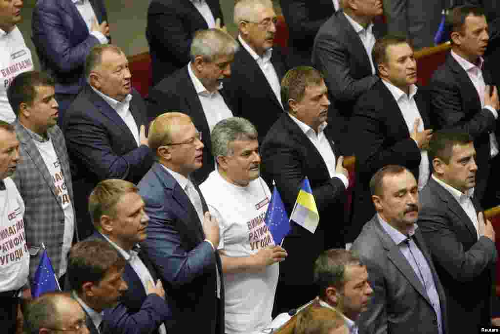 Ukraina Parlamenti deputatlari sharqiy Ukrainaga kengroq avtonomiya berish haqidagi qonunni qabul qilgach, milliy madhiyani kuylamoqda, 16-sentabr, 2014-yil, Kiyev, Ukraina.