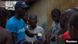 Seorang pekerja UNICEF (kiri) memberikan informasi mengenai Ebola terhadap masyarakat di Conakry, Guinea (foto: ilustrasi).