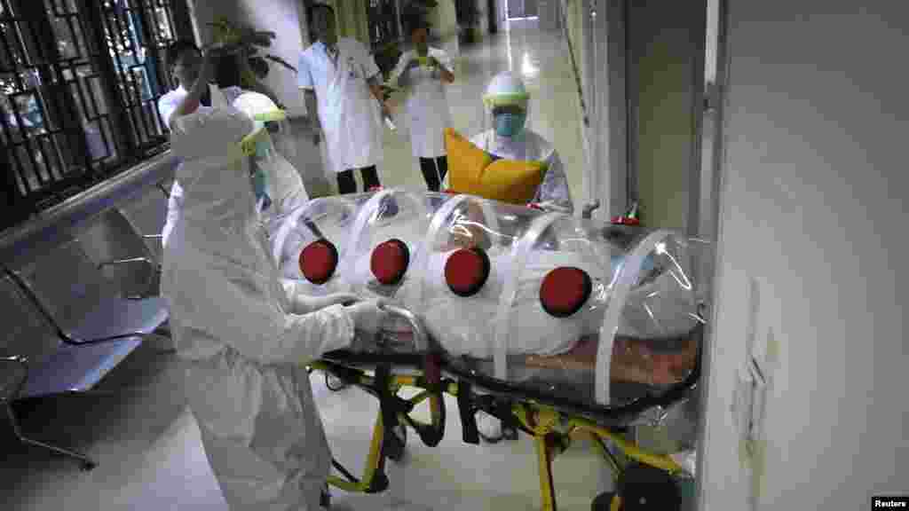 Des agents de service de santé simulent le transport d'un patient d'Ebola à la quarantaine à P Guangzhou, ChinE. Le 16 octobre 2014. REUTERS/Stringer