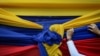 Un partidario de la oposición sostiene una tela con los colores de la bandera venezolana antes de un mitin con el líder opositor Juan Guaidó en el barrio Montalbán de Caracas, Venezuela, el 11 de enero de 2020.